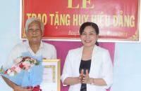 Đồng chí Lê Thị Nhung, Phó Chủ tịch điều hành Hội đồng nhân dân tỉnh trao huy hiệu Đảng cho đảng viên cao niên tại huyện Cái Nước.
